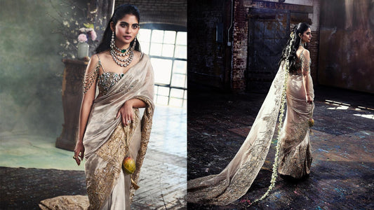 Isha Ambani in a silver sari carrying the hand-crocheted Mango Jaal with Subodh Gupta’s bronze mango sculpture